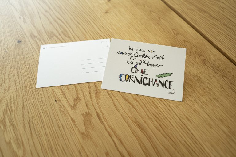weiße Postkarte mit bunter Schrift "Im Fall von saurer Gurken Zeit. Es gibt immer eine Cornichance"